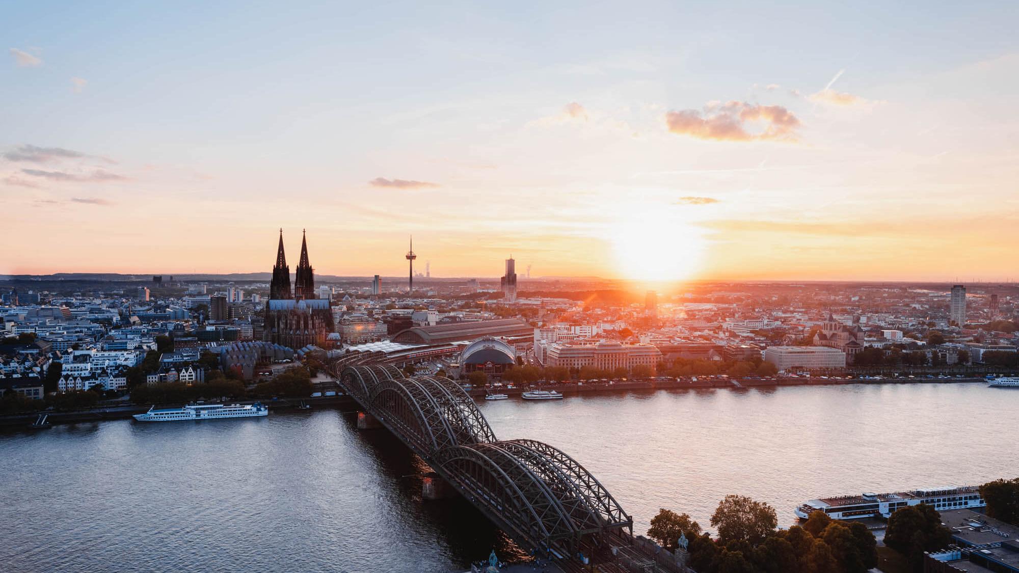 Sonnenuntergang fotografiert von der linken Rheinseite. Man sieht den Kölner Dom und die Hohenzollernbrücke.