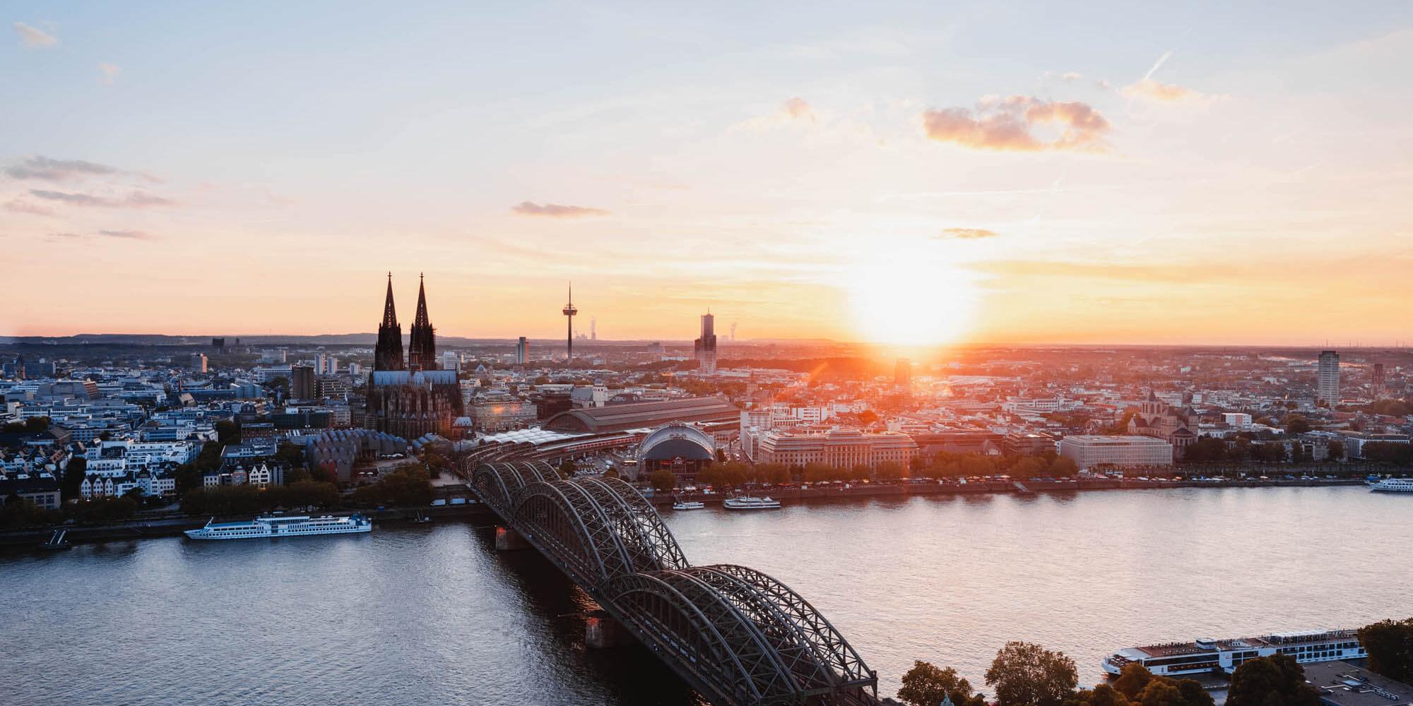 Sonnenuntergang fotografiert von der linken Rheinseite. Man sieht den Kölner Dom und die Hohenzollernbrücke.