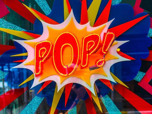 'Pop' neon light (c) Photo by Jean-Philippe Delberghe on Unsplash Neonlicht mit dem Schriftzug 'Pop' in Rot-Gelb auf einer bunten Glasscheibe.